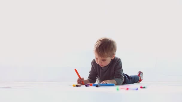 Küçük çocuk renkli kalemler kağıt üzerinde çizer. — Stok video