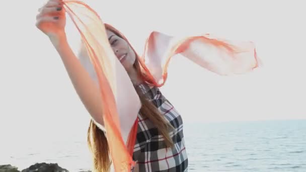 Mooie vrouw met een rode sjaal waait in de wind — Stockvideo