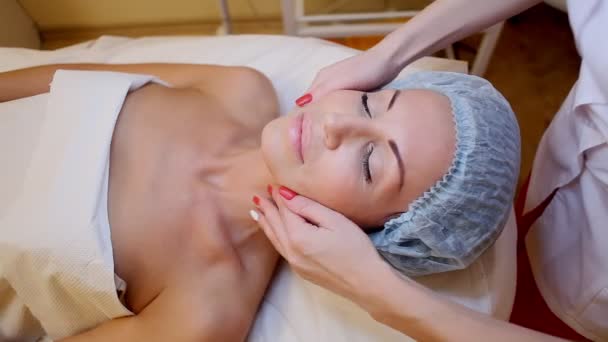 Cosmetólogo hace una mujer masaje de cara y cuello Spa — Vídeos de Stock