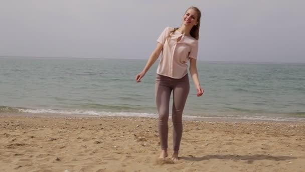 Blond kvinna dansar och skrattar på stranden — Stockvideo