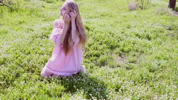 Blonde vrouw en bloemen in de tuin in het voorjaar — Stockvideo