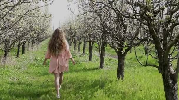 Blondin på en blommande trädgård och njut av dofterna av — Stockvideo