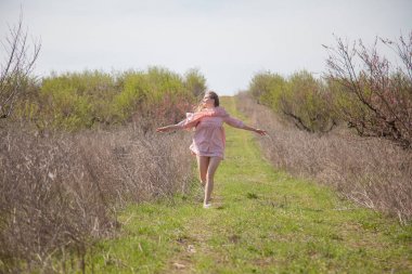 pembe elbiseli sarışın kız yol boyunca çalışır