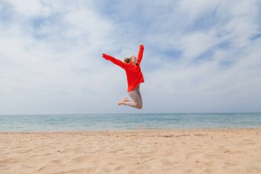 Kız bir kumsal deniz kıyısında atlama