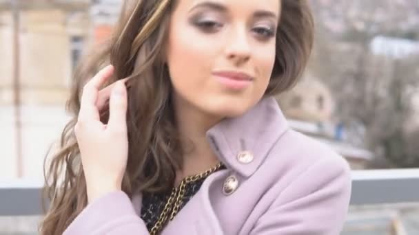 Красивая девушка, идущая в пальто по улице — стоковое видео