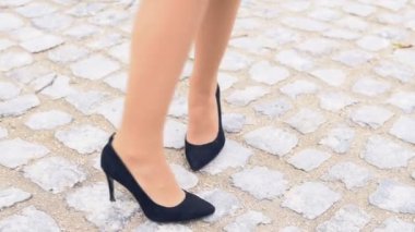Bayan bacaklar bir taş yolda siyah ayakkabı