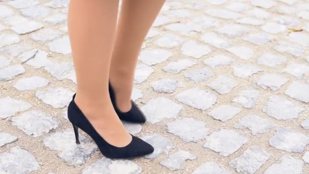 Gambe delle donne in scarpe nere su una strada di pietra — Video Stock