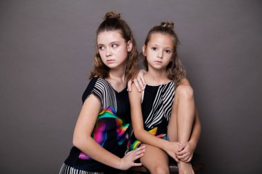 gri bir arka plan üzerinde iki kız moda portre