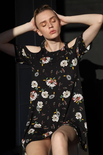 Модна блондинка в чорній сукні з квітами — стокове фото