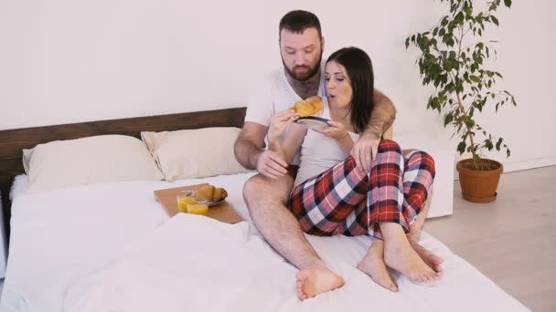 一个男人和一个女人早上醒来, 在床上吃早饭 — 图库视频影像