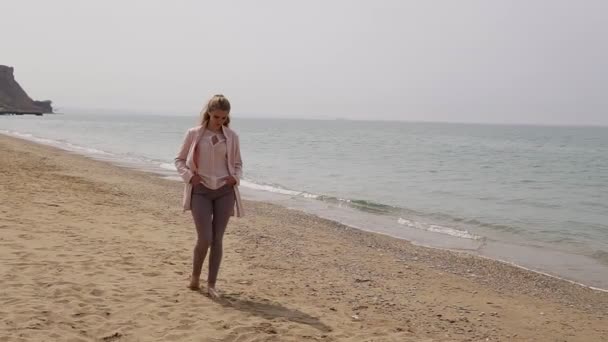 Una donna bionda sulla spiaggia in riva al mare — Video Stock