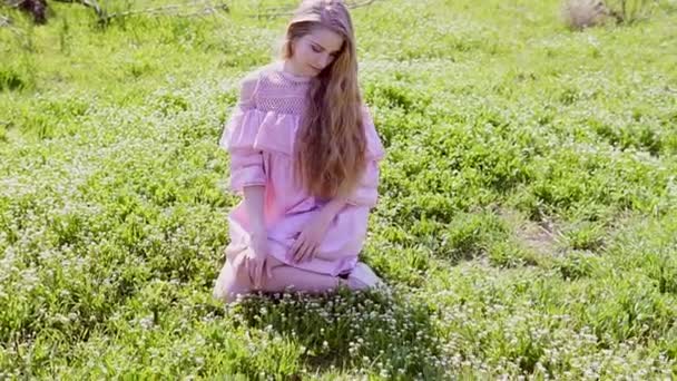 Blonde vrouw en bloemen in de tuin in het voorjaar — Stockvideo