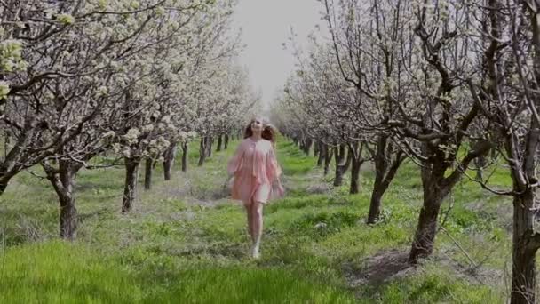 Blondin på en blommande trädgård och njut av dofterna av — Stockvideo