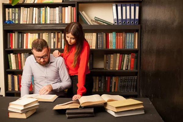 Un homme et une femme lisent des livres à la bibliothèque se préparent pour l'examen — Photo