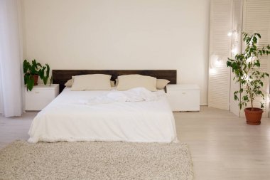 beyaz yatak odası yatak ve yeşil bitkilerde