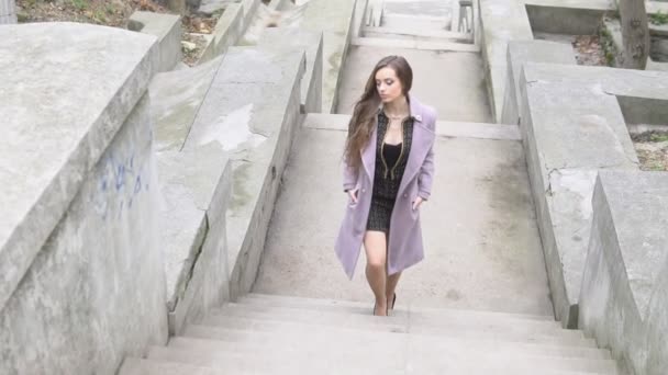 Bella donna in cappotto sale le scale — Video Stock