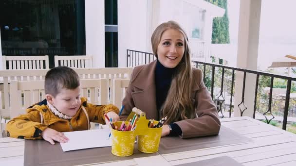 Mãe e filho jovem estão desenhando em uma mesa — Vídeo de Stock