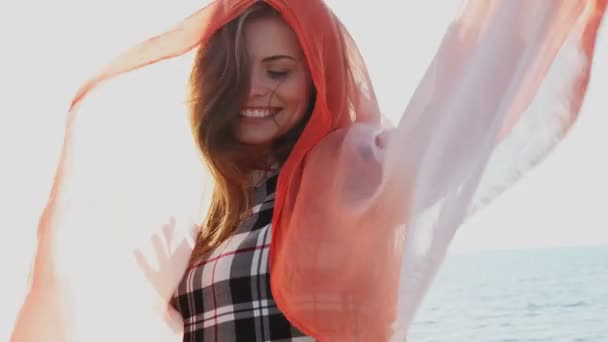 Bela mulher com um xale vermelho está soprando no vento — Vídeo de Stock