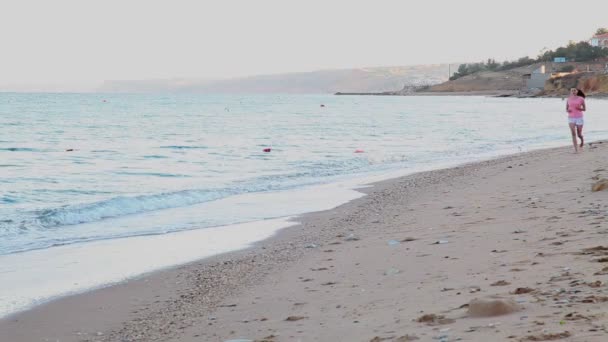 Lány a strandon, a tenger partján jogging — Stock videók