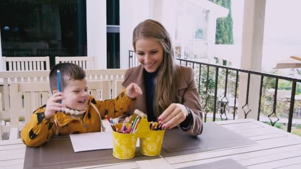 Madre e hijo pequeño están dibujando en una mesa — Vídeo de stock