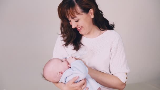 Moeder is het voeden van de baby melk uit een fles — Stockvideo