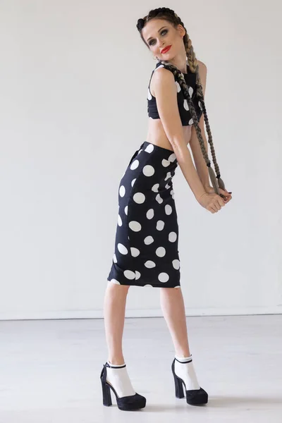 Beautiful fashionable woman braids in polka dot dress — Stock Photo, Image