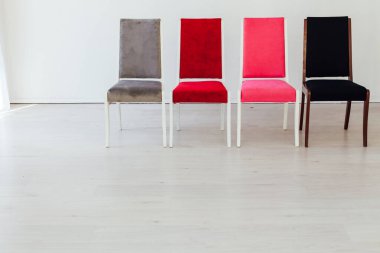 Boş beyaz bir odada dört sandalye duruyor.