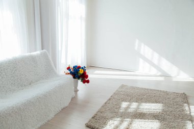 Çiçekli beyaz kanepe Beyaz odada tek başına duruyor