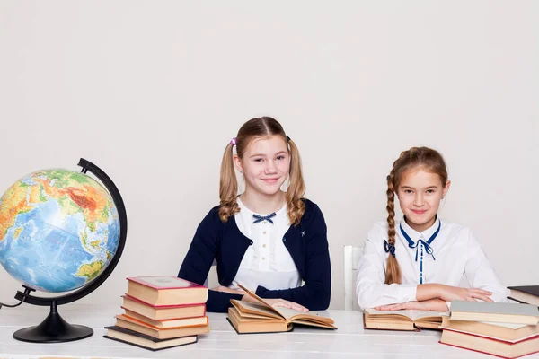 Две школьницы за столом в классе географии — стоковое фото