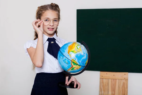 Schoolmeisje meisje studies globe op school op aardrijkskunde — Stockfoto