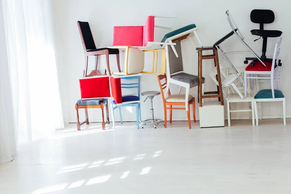 Muitas cadeiras multicoloridas ficar na sala branca — Fotografia de Stock