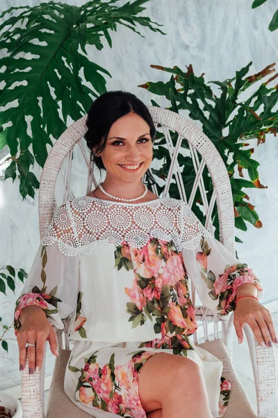 Portrait of a beautiful brunette woman in green plants
