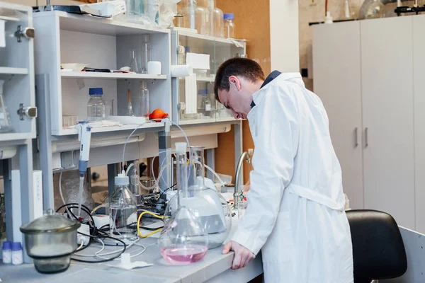 Чоловічий вчений проводить хімічні експерименти з рідинами в медичній лабораторії — стокове фото