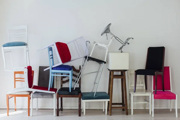 다양 한 색상의 많은 의자들이 흰 벽에 서 있다 — 스톡 사진