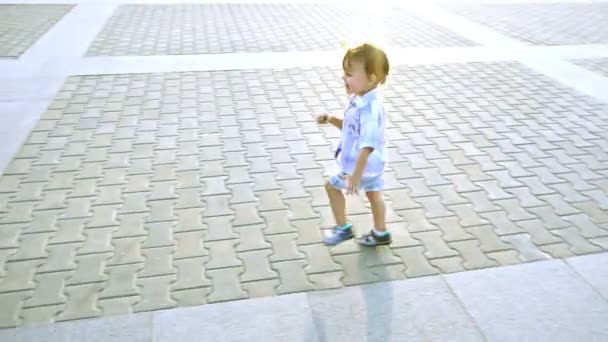 Kleine jongen rent rond op de pleinen van de zomer — Stockvideo