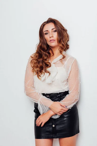 Портрет красивой модной женщины с кудряшками в блузке и черной юбке — стоковое фото