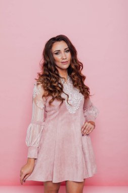 Pembe elbiseli, kıvırcık saçlı güzel bir kadının portresi.