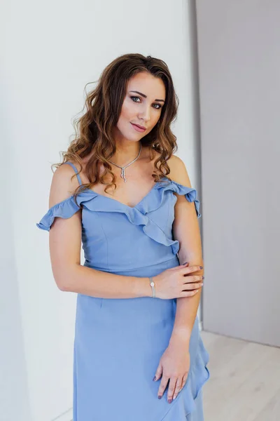 Retrato de una hermosa mujer de moda con rizos en un vestido azul —  Fotos de Stock