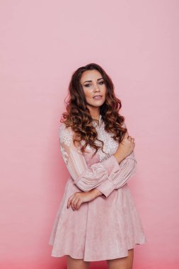 Pembe elbiseli, kıvırcık saçlı güzel bir kadının portresi.