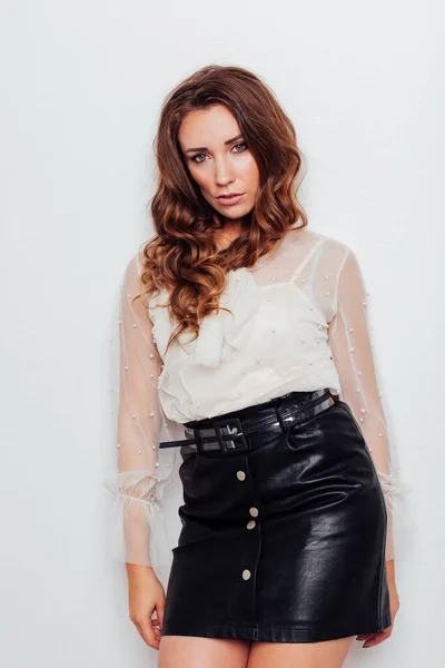 Portrait of a beautiful fashionable woman with curls in a blouse and black skirt — Stock Photo, Image