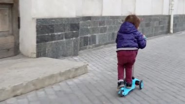 Çocuk parkta scooter kullanıyor. Kaygısız çocukluk