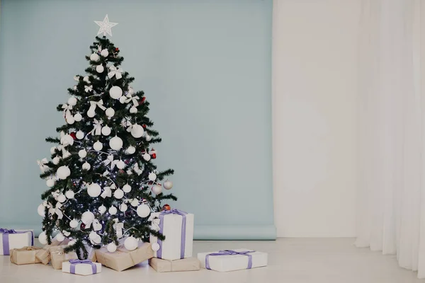 Árvore de ano novo em guirlandas de Natal no fundo branco azul — Fotografia de Stock