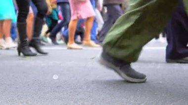 Yürüyen ve dışarıda sırada duran insanların bacaklar.