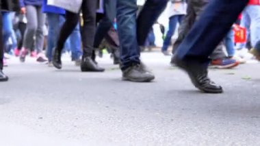 Yürüyen ve dışarıda sırada duran insanların bacaklar.