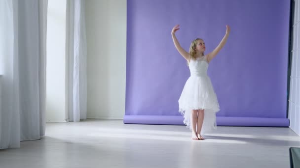 Девушка в белом танцует музыку — стоковое видео
