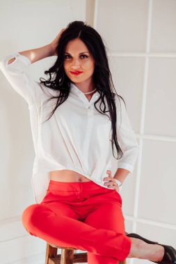 Kırmızı beyaz iş kıyafetleri içinde güzel esmer bir kadının portresi.