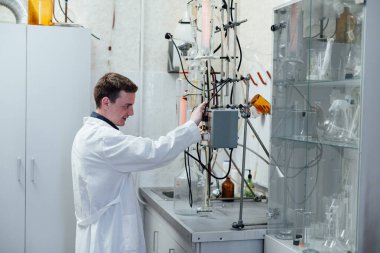 Erkek bilim adamı tıp bilimi laboratuvarında kimyasal deneyler yapıyor.