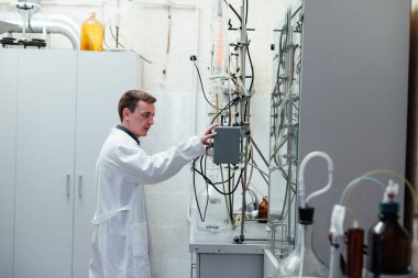 Erkek bilim adamı tıp bilimi laboratuvarında kimyasal deneyler yapıyor.