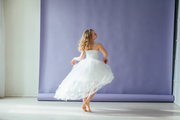 Menina bonita de 10 anos dançando em um vestido branco — Fotografia de Stock