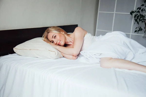 Mooie blonde vrouw in de ochtend in de slaapkamer op het bed — Stockfoto